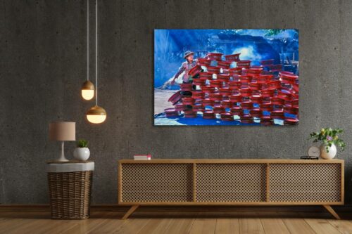 Een foto op plexiglas met een Burmese vrouw die rood gelakte tafeltjes aan het opstapelen is hangt aan de muur in een hippe woonkamer