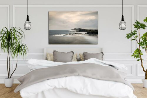 Slaapkamer met foto aan de muur van rotsen in zee