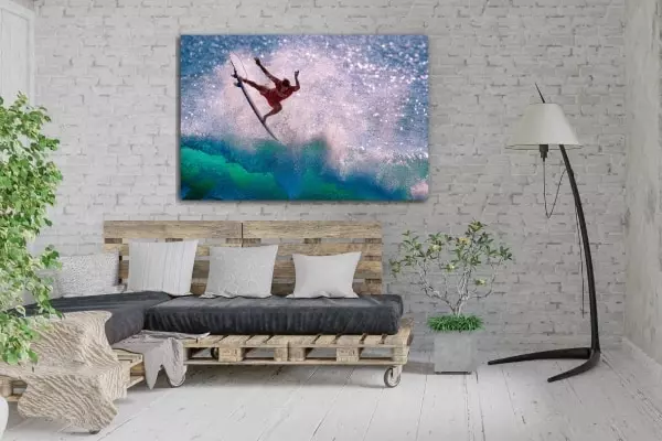 Fotokunst met golfsurfer aan de muur boven bank van pallets