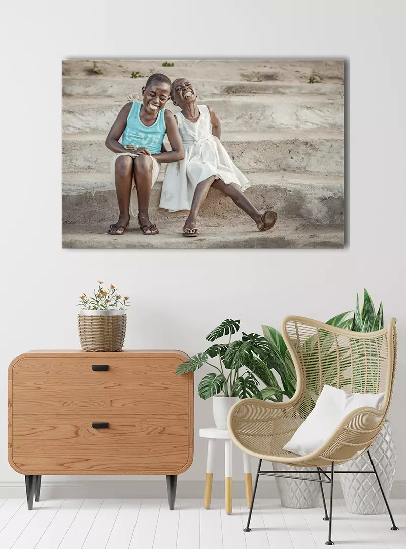 Woonkamer met foto aan de muur van Afrikaanse kinderen die de slappe lach hebben