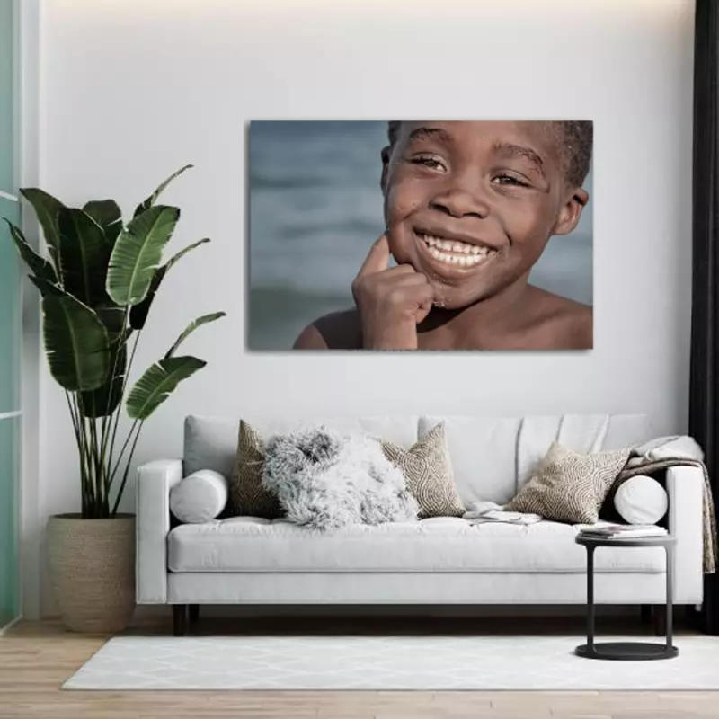 Fotokunst 'Big Smile' aan de muur boven witte bank