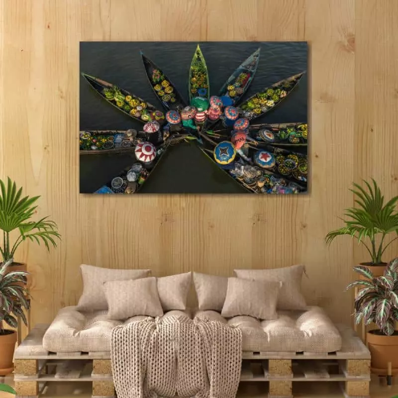 Bank van pallets met daarboven kunst aan de muur met afbeelding van kleurrijke drijvende markt