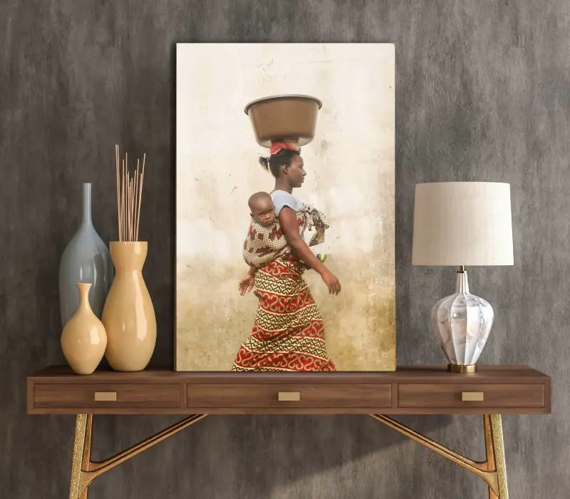 Fotokunst op plexiglas met afbeelding van Afrikaanse vrouw met draagdoek met baby  op tafeltje