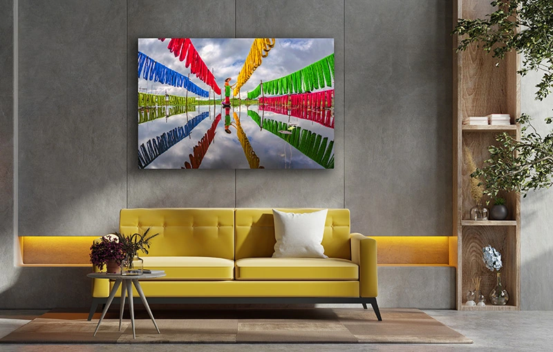 Woonkamer met gele bank en fotokunst 'Making Fabrics' aan de muur